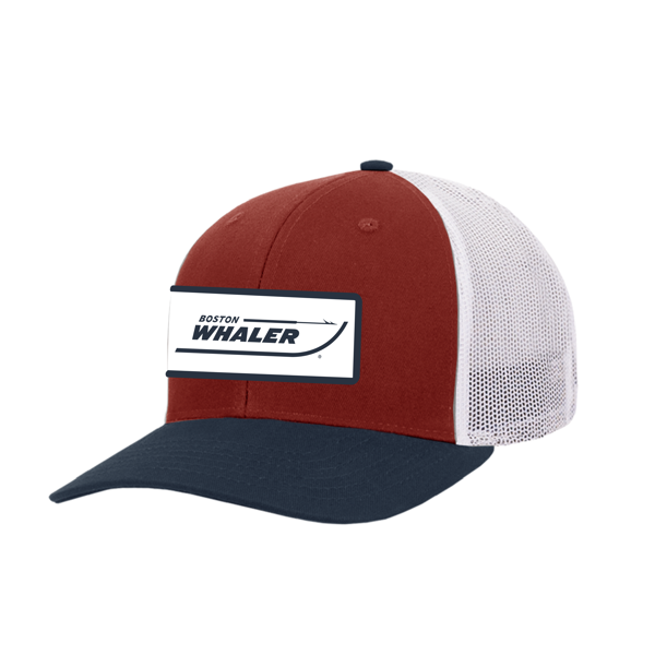 A trucker hat with a red front panel, navy blue bill, and a white mesh back. It features a Boston Whaler logo patch on the front.	